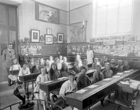 Classroom interior with children at desks 	