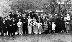 Wedding group. Photo taken at Clayworthy Mill (now Hancocks Cider Makers). Mill in background - there was a farmhouse to the right of the photo. The Wensley family lived at Bridge House - a cottage to the left of the photo. contd./. 	