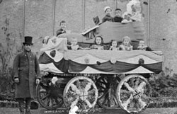 Carnival float, children in decorated cart. ' The old woman who lived in a shoe '. 	