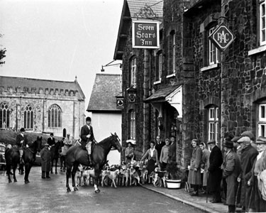 View of Hunt with hounds outside Seven Stars Inn. 	
