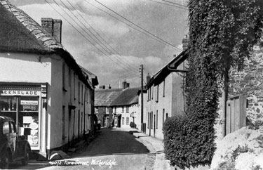 Fore Street. The shop and row of thatched cottages were knocked down for the widening of Fore Street. 	